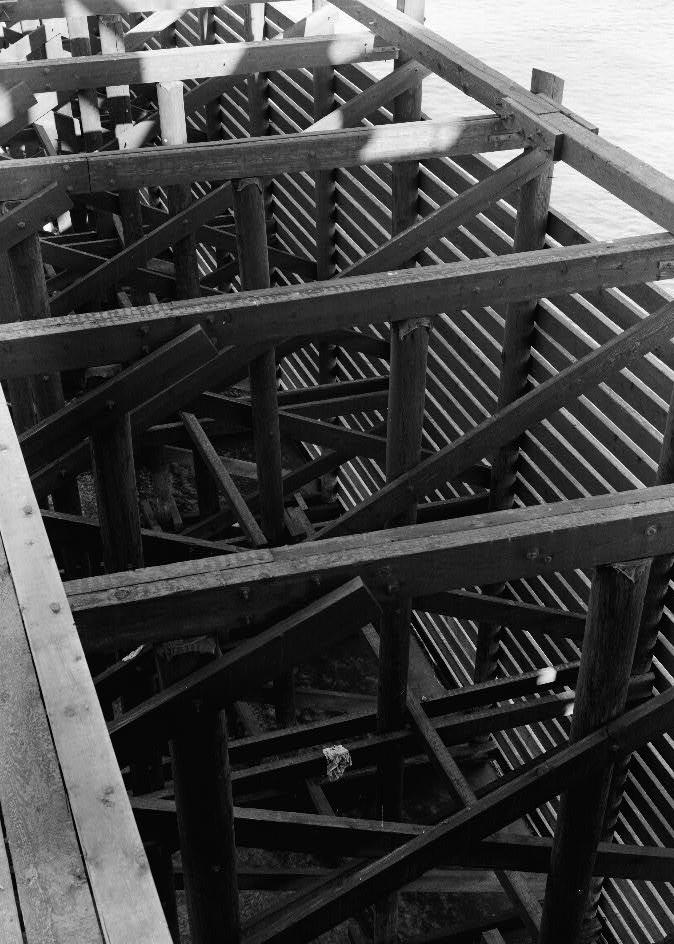 Willamette River Swing Truss Railroad Bridge, Portland Oregon 1985 NORTH PIER PROTECTION FRAMING. SERVICE WALKWAY ON LEFT, TIMBER PILE CONSTRUCTION, TIMBER FRAMING, HORIZONTAL 4 X 10 SHEATHING, BOLTED AND SPIKED FASTENINGS