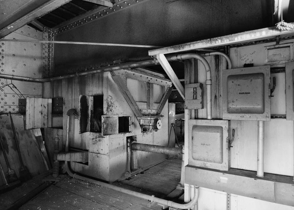 Willamette River Swing Truss Railroad Bridge, Portland Oregon 1985 NORTH SIDE OF CENTER DRUM MACHINERY ROOM. MOTOR #1 COMPARTMENT IN REAR, AUXILIARY MOTOR DRIVE SHAFT, POWER PANELS ON BACK OF AUXILIARY MOTOR HOUSE. BRIDGE DECK FRAMING ABOVE.