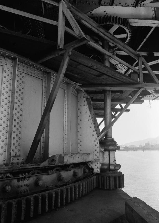 Willamette River Swing Truss Railroad Bridge, Portland Oregon 1985 SOUTH SIDE OF CENTER DRUM, ONE BULL SHAFT AND GEARS, BULL RING AND ROLLERS, AND TOP OF PIER III. WILLBRIDGE AND PORTLAND WEST HILLS IN BACKGROUND.