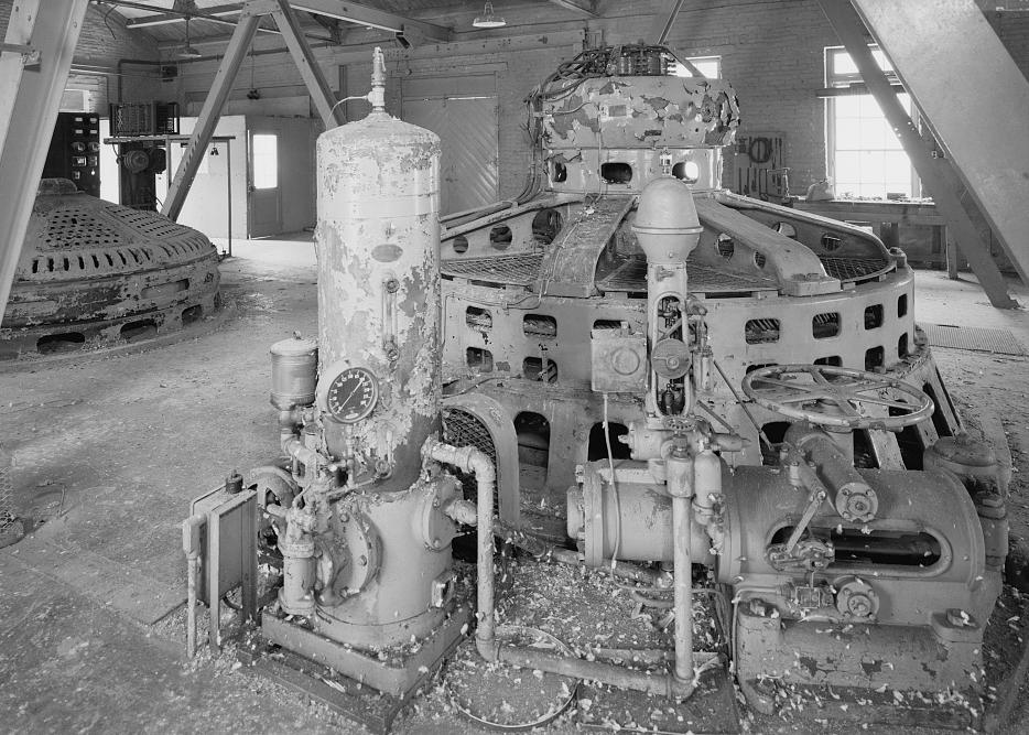 INTERIOR OF POWER PLANT BUILDING LOOKING SOUTH AT 1925 GE GENERATOR. GOVERNOR MECHANISM IN FOREGROUND MANUFACTURED BY THE WOODWARD GOVERNOR COMPANY, ROCKFORD, ILLINOIS (NAMEPLATE ON LEFT) (1995)