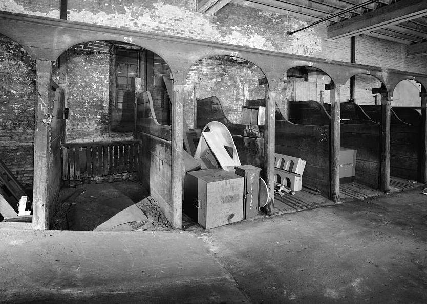 Baltimore & Ohio Railroad, Mount Clare Shops, Baltimore Maryland INTERIOR OF STABLES SHOWING HORSE STALLS LOOKING DOWN OPPOSITE WING (1976)